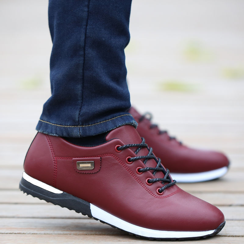 Baskets cuir imperméables rouges portées avec pantalon jean bleu sur sol en bois