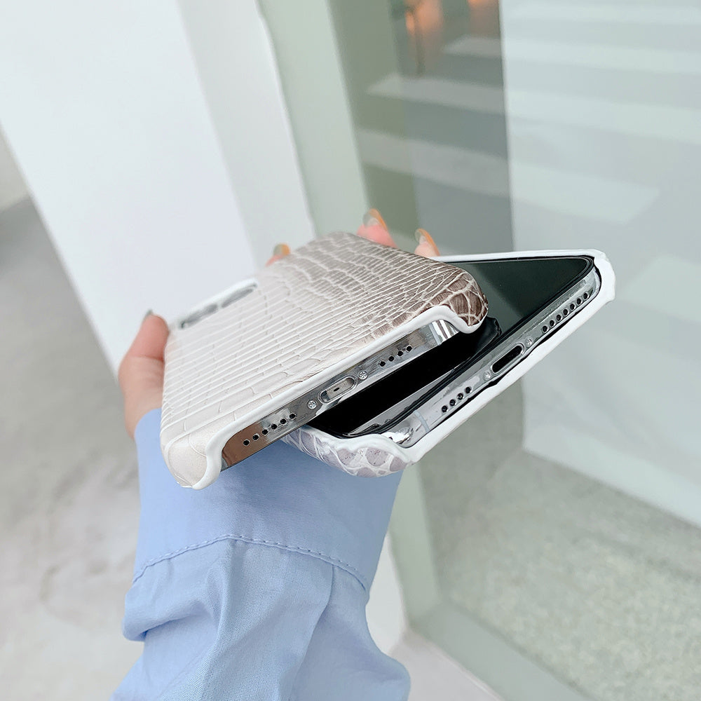 Coque téléphone cuir crocodile beige élégante avec texture en relief tenant un smartphone