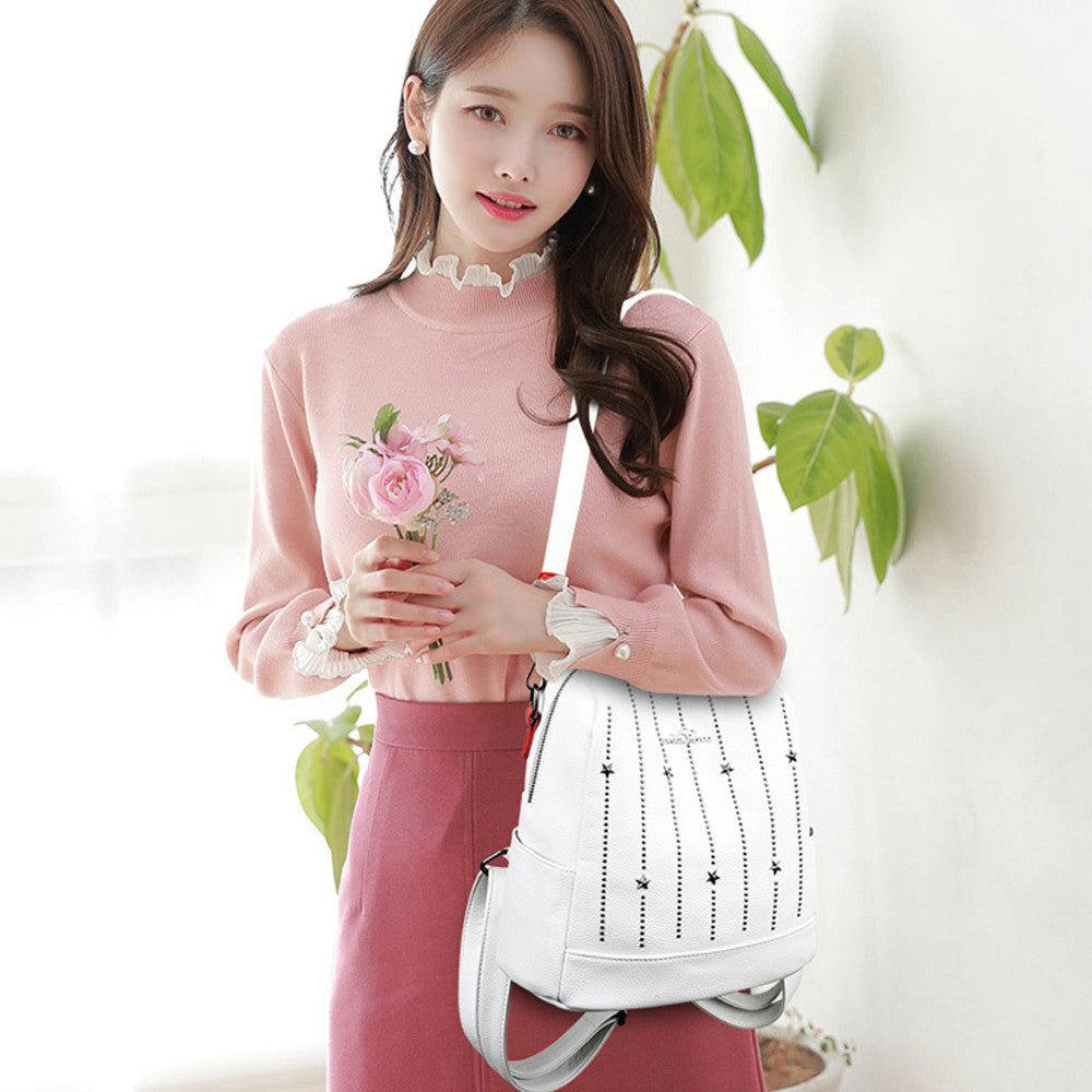 Sac à dos en cuir femme blanc clouté style Gypsophila porté par une femme en pull rose