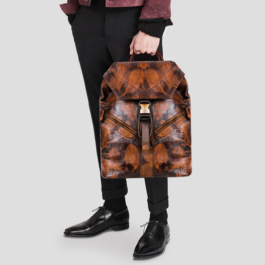 Sac à dos en cuir haut de gamme marron porté à la main par un homme en tenue élégante